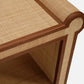 Close-up of the Small Matthew Console, highlighting its detailed craftsmanship with woven rattan and full-grain leather trim on the uniquely shaped arm and seat.