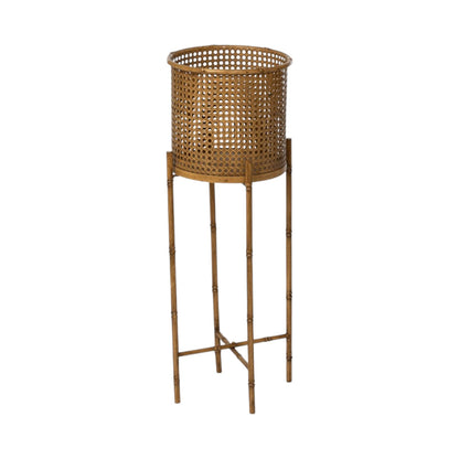 The Roanoke Metal Planter on Stand boasts modern elegance with its tall, gold-colored cylindrical basket on four slim legs and crossbars, all crafted from durable metal.