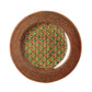 A round rattan placemat with a woven pattern and a green central design reflects the modern shapes and colors of the Mario Luca Giusti Patagonia Green Collection.