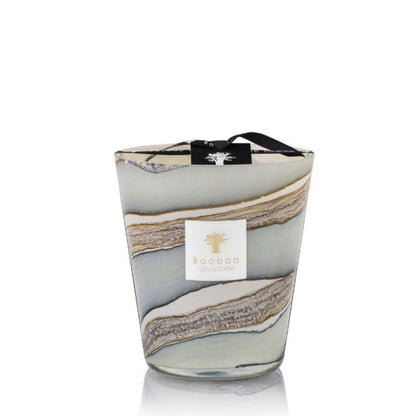 A decorative candle with a layered, marble-like design in earthy tones, infused with notes of myrrh and labeled "Baobab Collection Sand Sonora Candle," is elegantly completed with a black ribbon tied around the top.