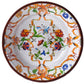 A decorative ceramic plate from the Mario Luca Giusti Pancale White Collection, featuring intricate floral and butterfly patterns in vibrant colors that reflect Mario Luca Giusti's aesthetic research and distinctive modern shapes.