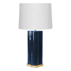 The Stratus Classic Table Lamp features a white fabric shade, glossy dark blue ceramic base, and gold-tone base plate, adding modern elegance to any space.