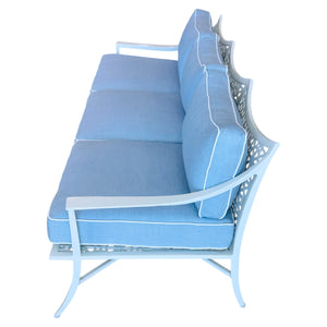 The Haret Outdoor Sofa features a light blue finish, three seat and back cushions, a metal frame with signature fretwork lattice detailing, and curved armrests, part of our Metal Outdoor Collection.