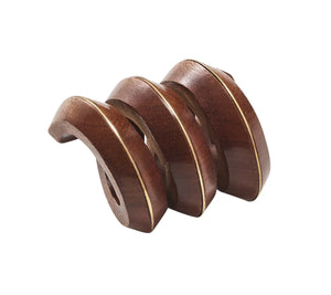 The Kim Seybert Brown & Gold Tendril Napkin Ring features three curved, hand-carved wooden pieces with brass inlays and a hole through the base, stacked side by side for a natural yet elegant table accent.