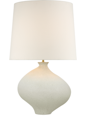 A Celia Large Left Table Lamp, Marion White with a white, rounded ceramic base and an oversized linen shade perfect for coastal interiors.