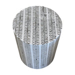 The Etched Stool, featuring a round shape and a pattern of black and white semicircles, creates a striking decorative accent when viewed from above.