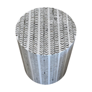 The Etched Stool, featuring a round shape and a pattern of black and white semicircles, creates a striking decorative accent when viewed from above.