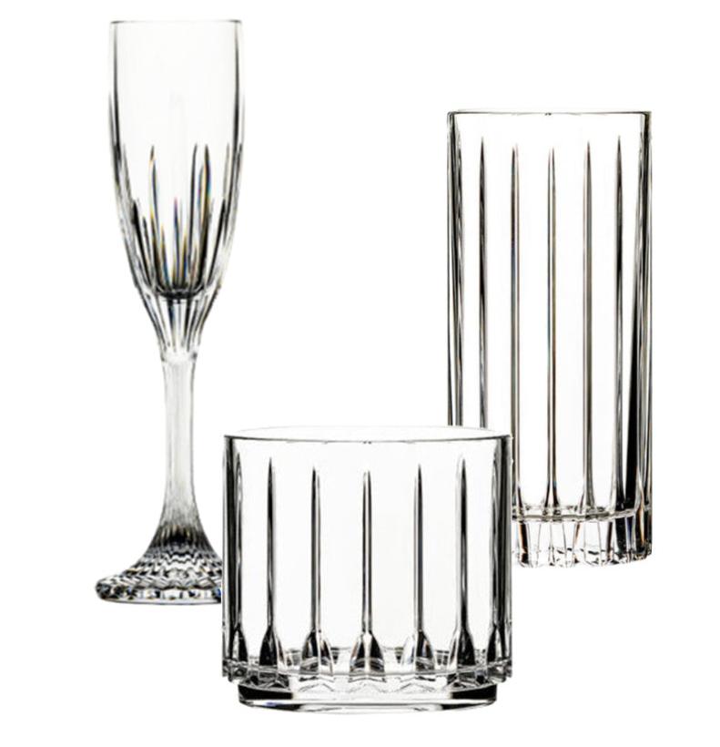 The Bold Tryst Acrylic Collection features three crystal-clear glasses: a champagne flute, a lowball glass, and a tall highball glass, each designed with a vertical line pattern and made from unbreakable materials.