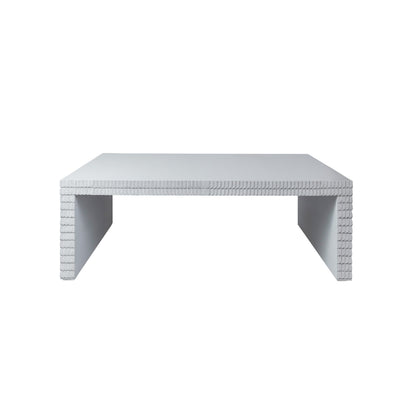 The Lance Coffee Table—rectangular and finished in white gesso with textured, block-like detailing on its legs and edge—is a striking example of contemporary design, making it the perfect addition to modern living room furniture collections.