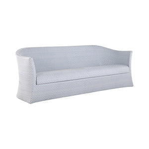 The Bari Sofa in Chambray is a modern three-seater outdoor sofa with a curved back and sides, crafted from resin wicker and featuring water-resistant light blue and white striped cushions.