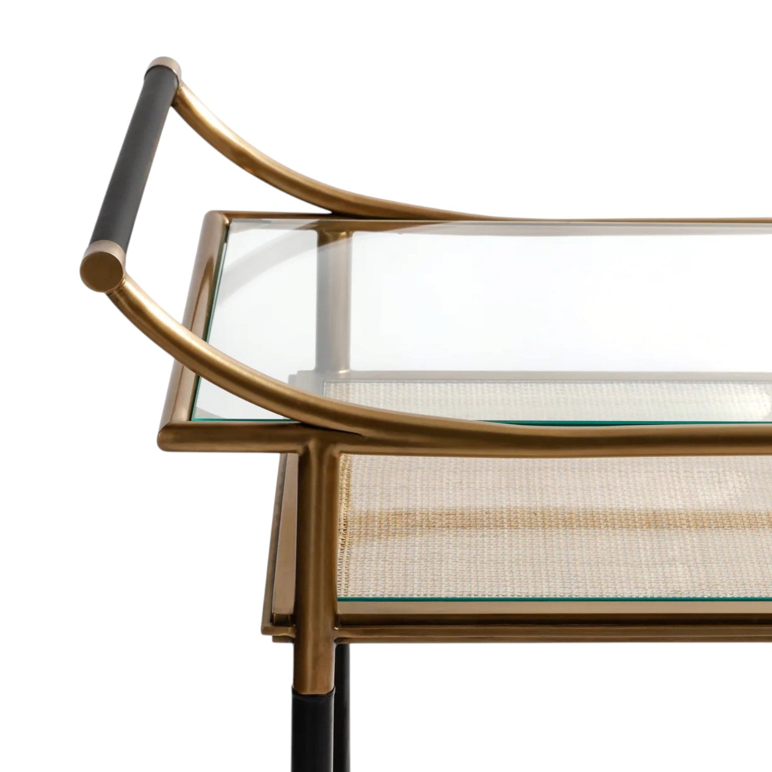 Close-up of the Mayfair 59 Bar Cart showcasing its glass top, vintage brass frame, black handle, and woven lower shelf—a stylish piece ideal for entertaining.