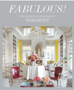 Cover of *"Fabulous!: The Dazzling Interiors of Tom Britt"* featuring an elegant living room with red chairs, a round table, floral centerpiece, and ornate chandelier in a brightly lit, yellow-accented space that epitomizes luxury and dramatic environments.