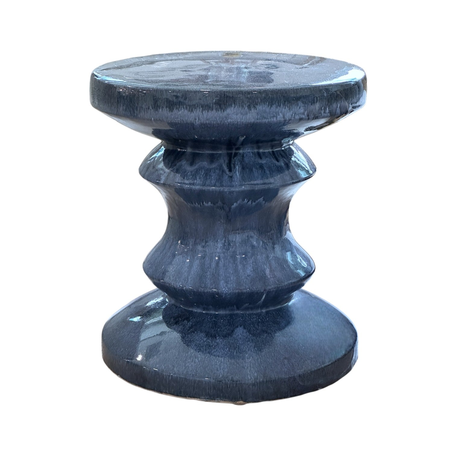 The Feathered Blue Chess Piece Stool features a glossy dark blue porcelain finish, a round top, and a sculpted symmetrical hourglass-shaped base.