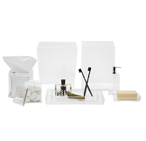 A cool bath collection of white bathroom accessories, featuring the Pigeon and Poodle Monette Collection tissue holder, cotton ball jar, containers, pump dispenser, soap, toothbrush holder, and tray.