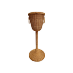 Champagne Stand: Tall woven wicker basket on a stand with two side handles, inspired by classic champagne stands, shown isolated on a white background.