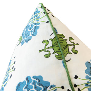 Corner of the Peony Bluebell Pillow, a white custom-made design adorned with blue floral and green turtle patterns, featuring a green piped edge and a hidden zipper closure.