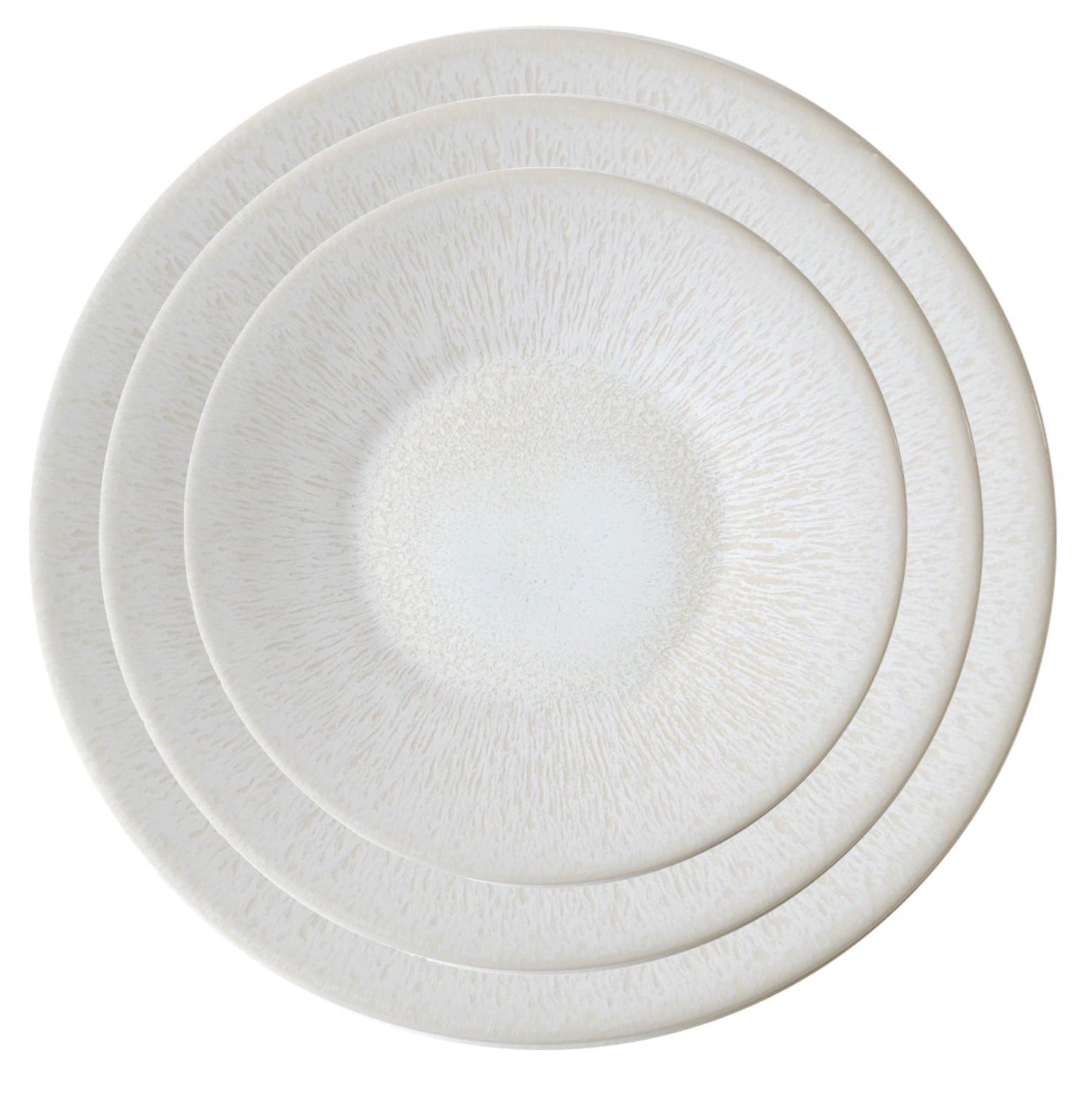 Four nested Jars Vuelta White Pearl Collection plates with textured center designs are arranged in descending size order, showcasing a classic and refined aesthetic.