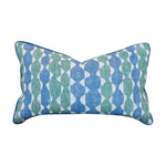 The Whittle Blue Green Lumbar Pillow features a blue and green geometric pattern on a white background, complemented by blue piping along the edges and a hidden zipper closure for a seamless finish.