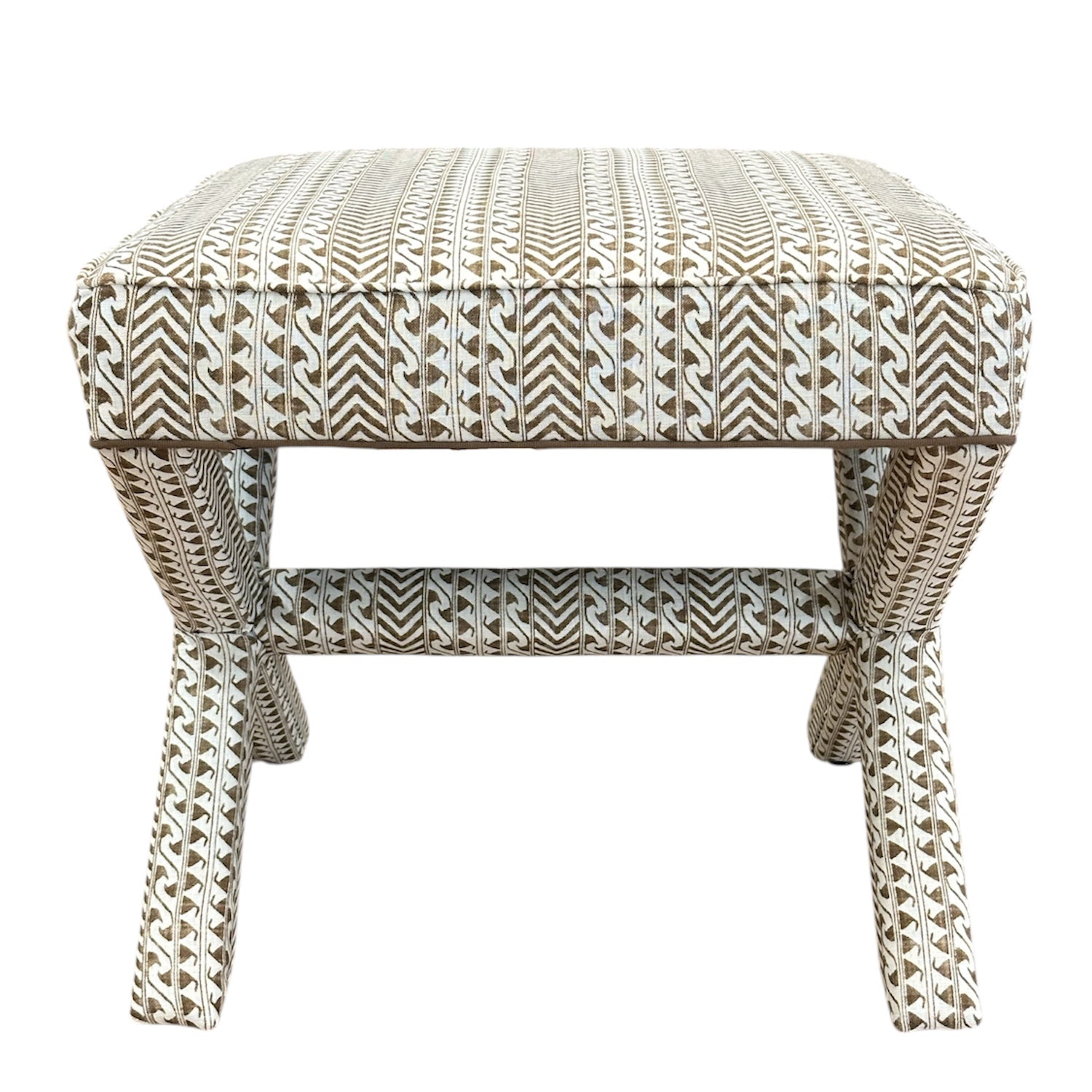 The X Bench features a sophisticated design with custom brown and white geometric upholstery, four angled legs, and a lower connecting bar.