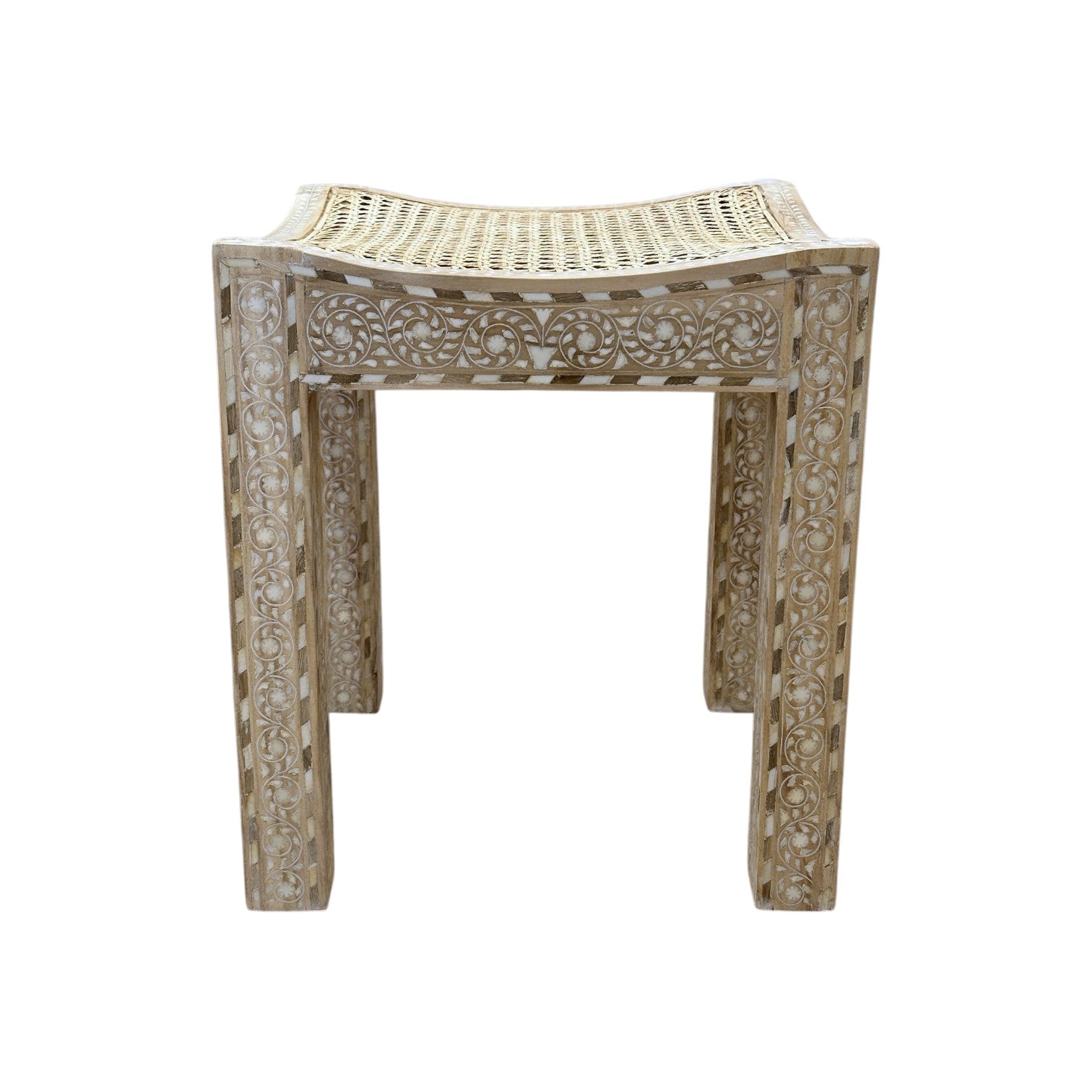 The Cane Stool features carved decorative patterns on its wooden legs and a woven cane seat, shown against a white background.