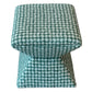 The Hamilton Outdoor Ottoman in Boheme Green features a square upholstered design with a teal and white geometric pattern, a wide top, and narrow base—ideal for enhancing your patio decor.