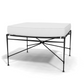 The Amalfi Ottoman showcases a minimalist look with a white cushion and black hand-forged steel frame, featuring a geometric cross-braced base.
