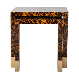 The Raleigh Nesting Table stands out with its striking Tortoise Finish and brass-accented legs, offering a sophisticated look against a crisp white backdrop.