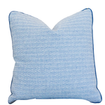 The Roxam Blue Pillow is a square, light blue woven pillow with subtle horizontal stripes and dark blue piped edges. It features a hidden zipper closure for a seamless look and is showcased against a white background.