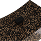 Close-up of the Yarin Box, a rectangular black button displayed on a patterned surface reminiscent of leopard print, evoking the elegance of an ancient Chinese empire pillow.