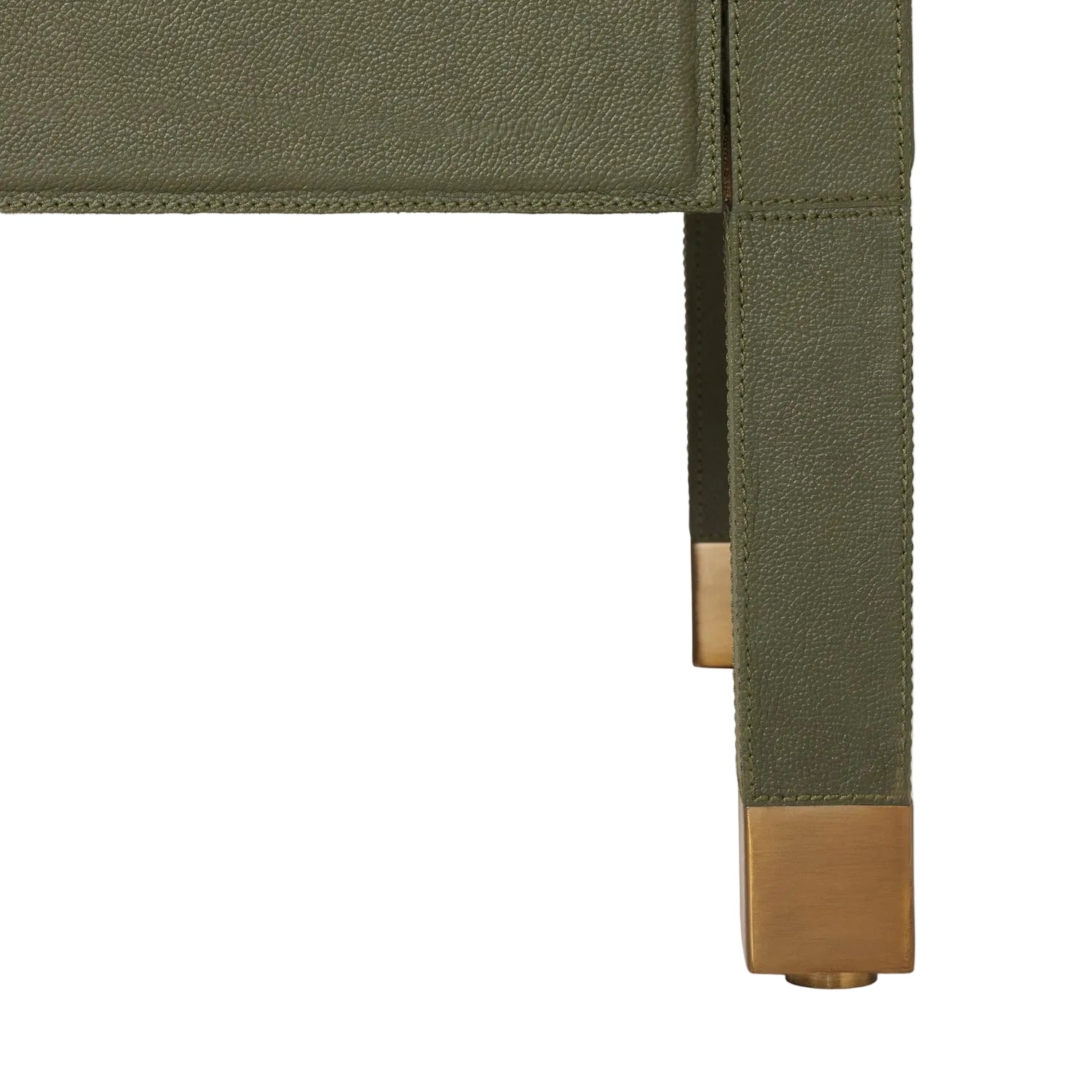 Close-up of the Conner Dresser’s corner, showing green textured finish, gold metal caps on wooden legs, and contrast stitching, set against a white background.