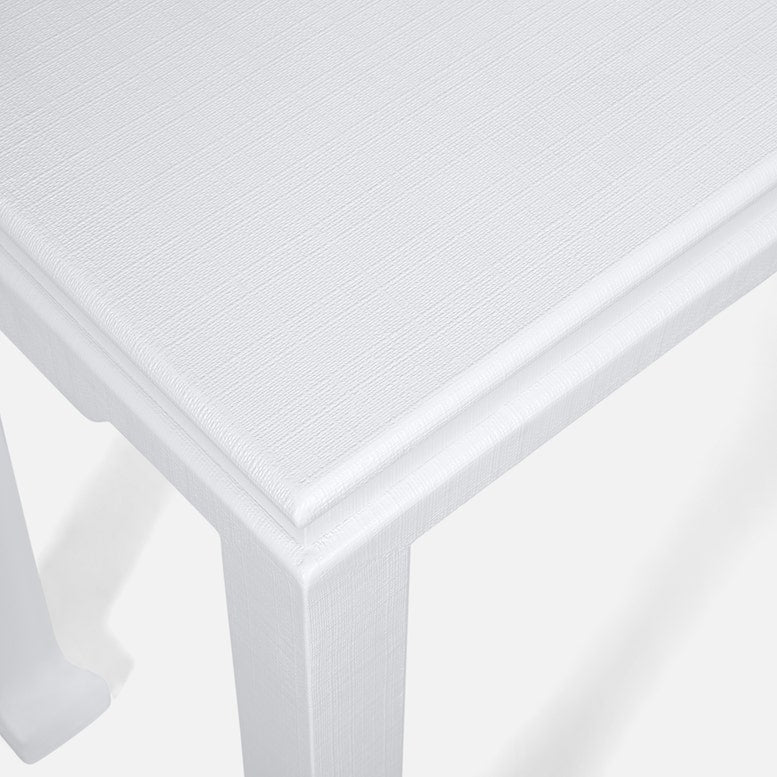 Close-up view of the corner of the Wylder Console, a white rectangular table with a textured surface and simple trim detail—a sophisticated piece that embodies timeless classic design.