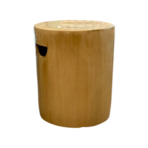 The Cylinder Stool in Latte is a cylindrical, light brown ceramic piece with a small oval cutout handle on the side, featuring a rustic antique look against a white background.