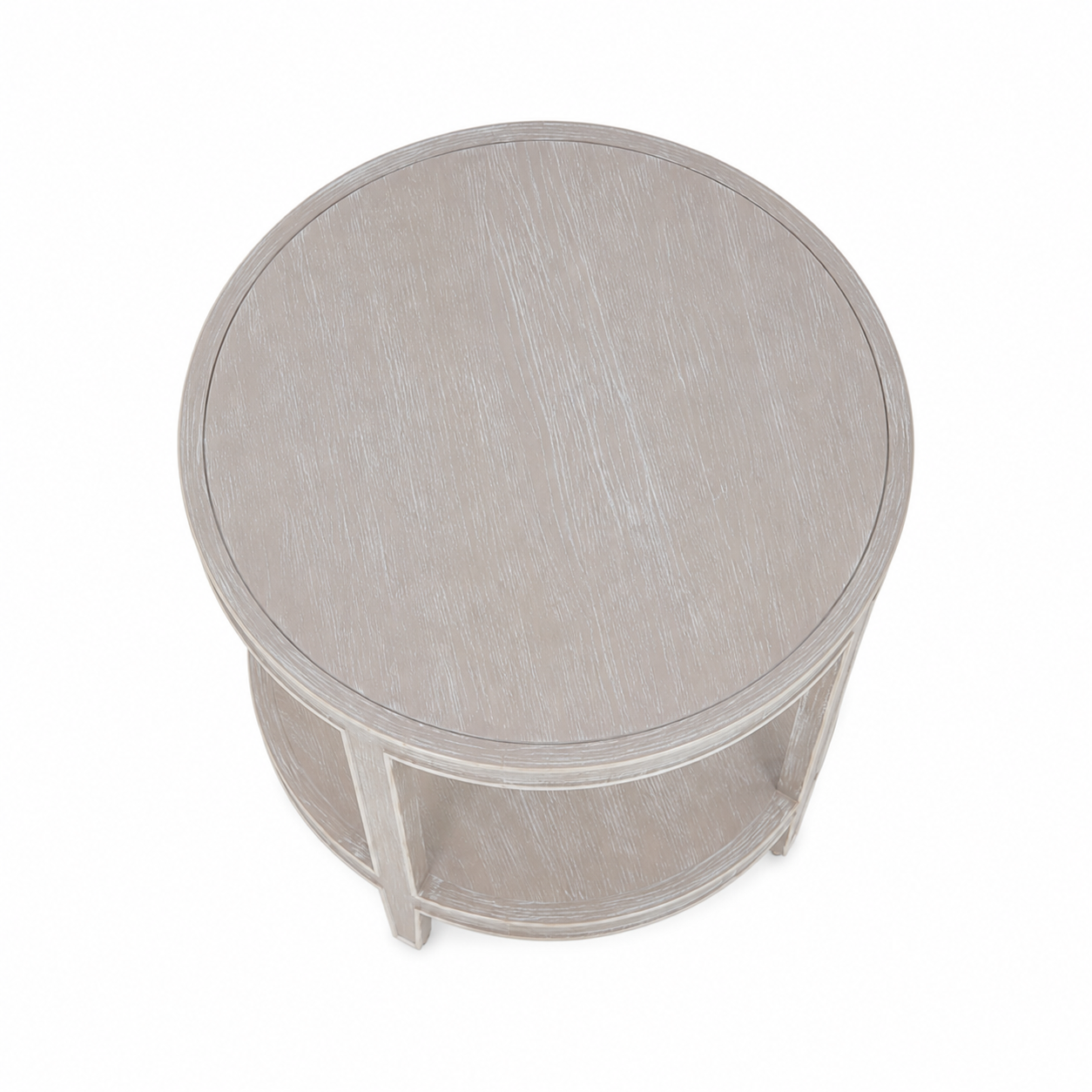 The Greenwich Chairside Table is a compact round table with a light, weathered finish, straight legs, and a handy lower shelf—versatile as an accent piece and shown from above.