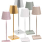 A group of six Zafferano Poldina Pro Cordless Lamps with varying shades of pink, gold, silver, white, and green, all featuring rectangular bases and cylindrical shades. These cordless illumination wonders come with rechargeable batteries for hassle-free use anywhere in your home.