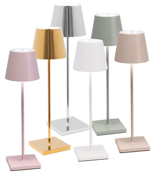 A group of six Zafferano Poldina Pro Cordless Lamps with varying shades of pink, gold, silver, white, and green, all featuring rectangular bases and cylindrical shades. These cordless illumination wonders come with rechargeable batteries for hassle-free use anywhere in your home.