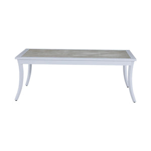 The Bermuda Coffee Table features a rectangular design with a light wood top and white, slightly curved legs for an elegant outdoor look.